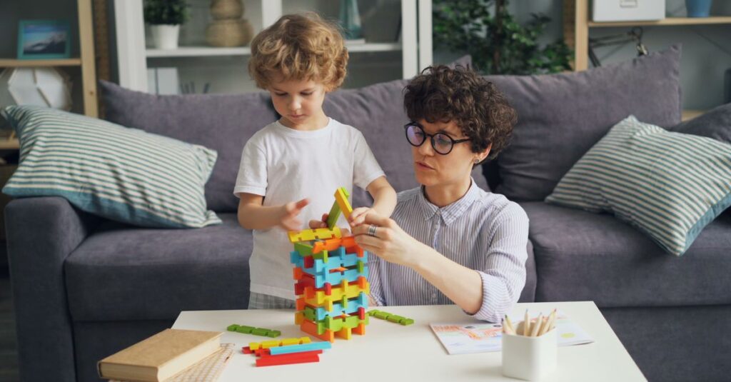 ブロックスを囲んで真剣な表情で戦略を練る家族の様子