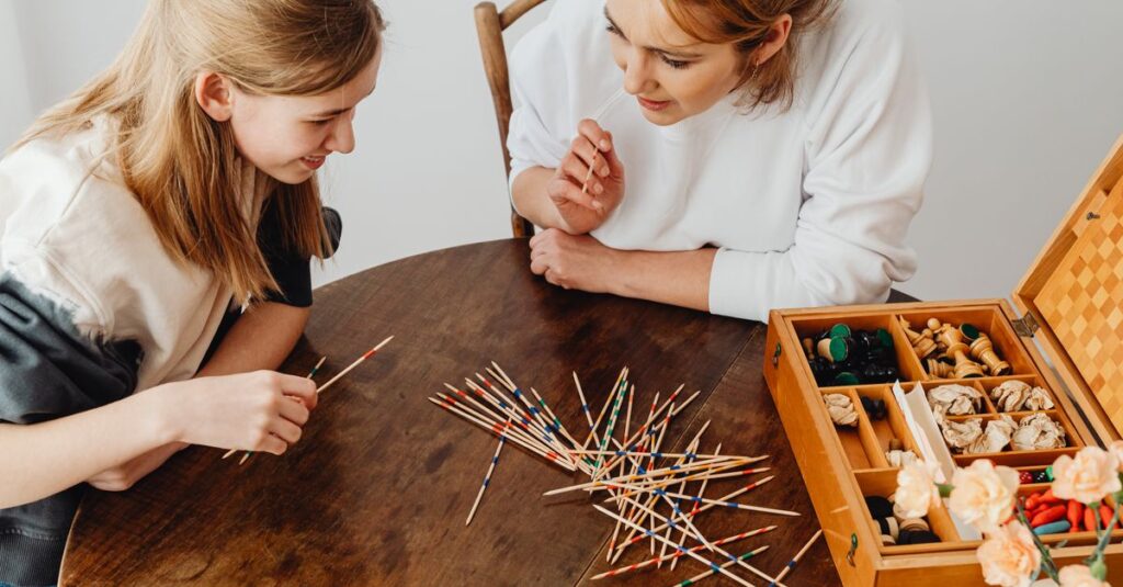 小学生の子どもたちと家族が家で人気のボードゲームを楽しんでいる様子