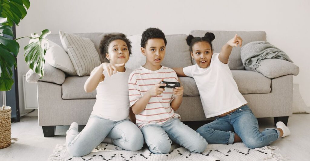 幼児と家族がボードゲームやカードゲーム、体を使った遊び、デジタルゲームを楽しんでいる様子。笑顔あふれるリビングのシーン