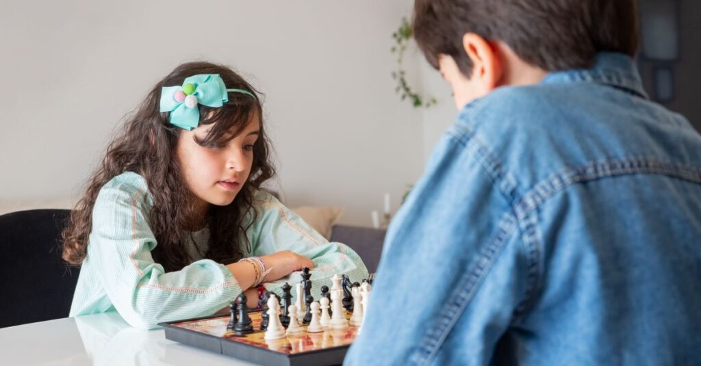 中高生と大人が戦略的なボードゲームで真剣勝負。知的な駆け引きが楽しい時間。