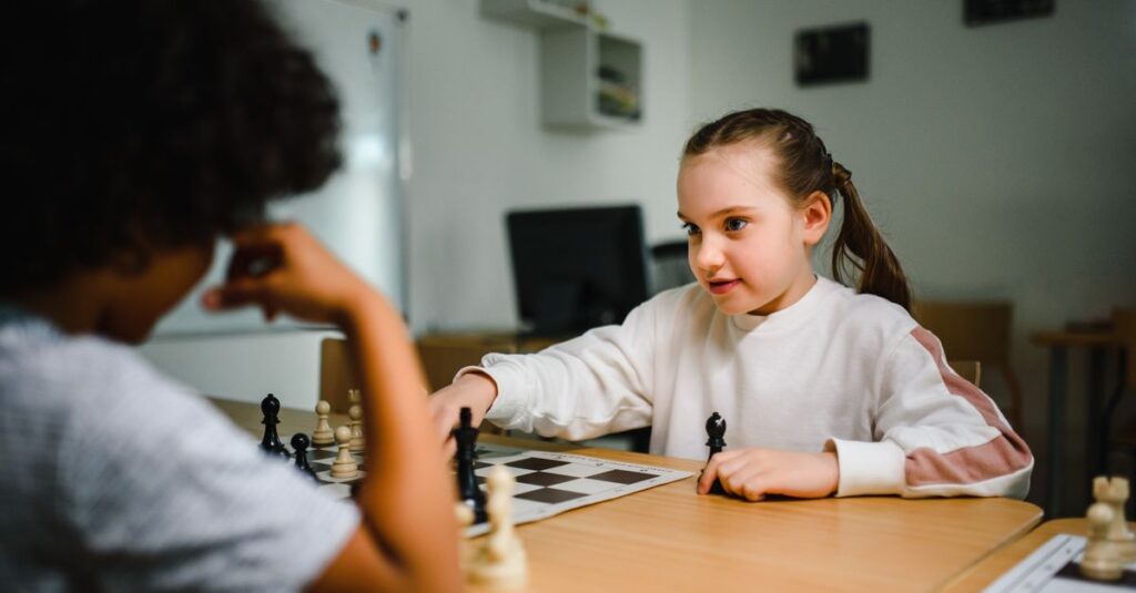 小学生が家族と一緒に真剣な顔でボードゲームに挑戦している様子