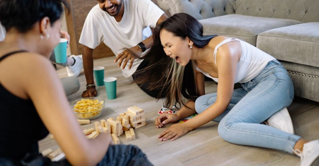 初心者たちがボードゲーム中に大笑いしている瞬間。勝ち負け以上に楽しさが伝わる場面。