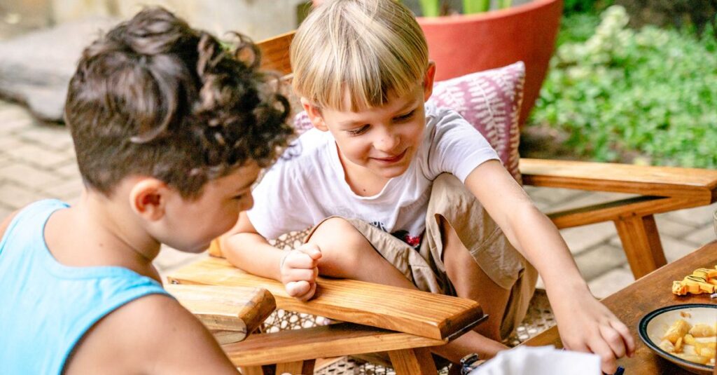 笑顔でボードゲームを楽しむ小学生男子たちの様子を表したイメージ