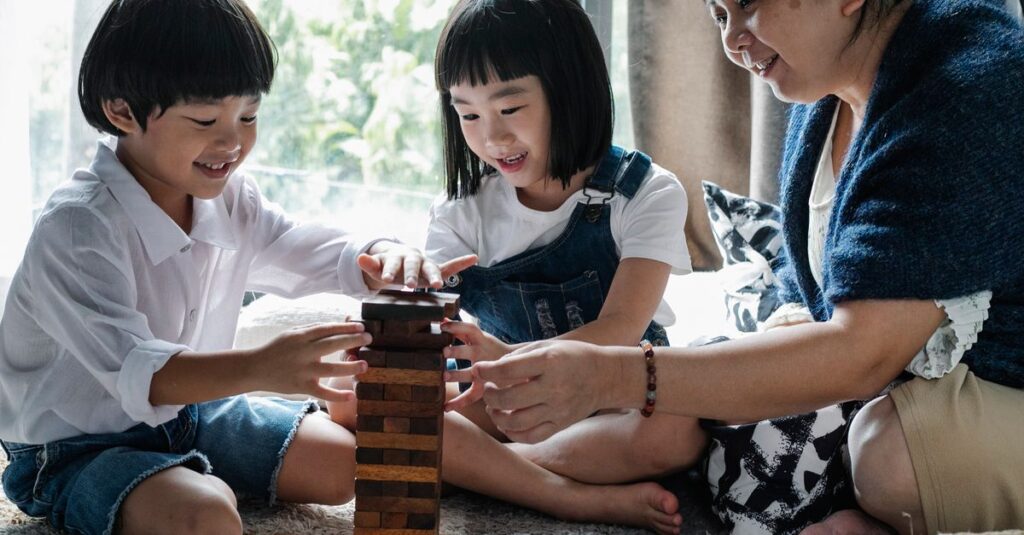 小学生の女の子と親がリビングでボードゲームを楽しみ、笑顔で会話している様子