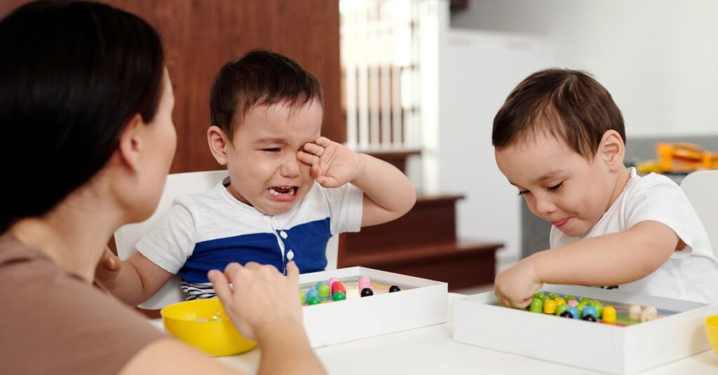 3歳から5歳の幼児が親と一緒にボードゲームを楽しみ、ルールを学びながら考える力や協調性を育てている様子