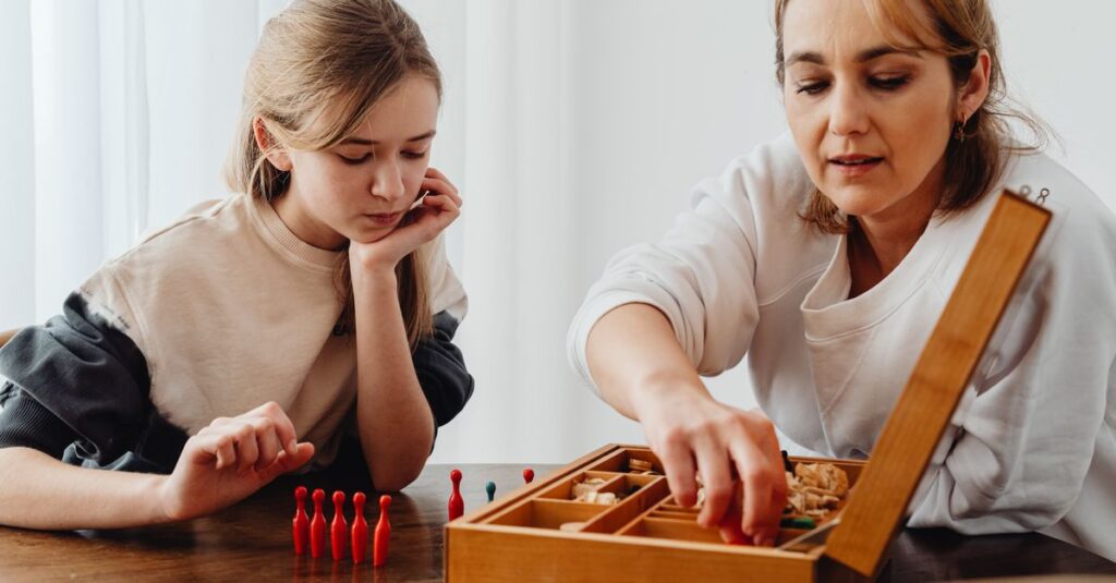 小学生の女の子が友達や親と一緒にボードゲームを楽しんでいる。カラフルでかわいいゲームが並んでいる