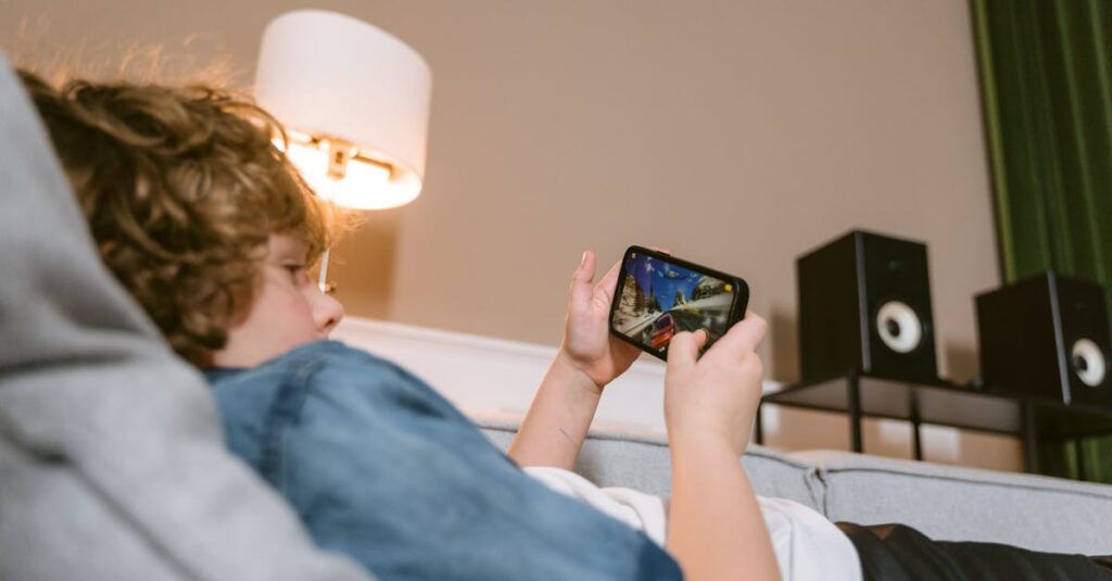 家族全員がスマホを手に持ち、並んでアプリゲームを楽しんでいる。ソファに座りながらリラックスした雰囲気。