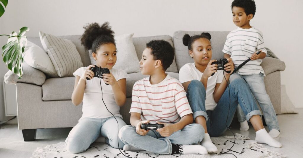 4人家族がリビングでテレビゲームを一緒に楽しんでいる。画面を見ながら笑顔でコントローラーを操作している様子。