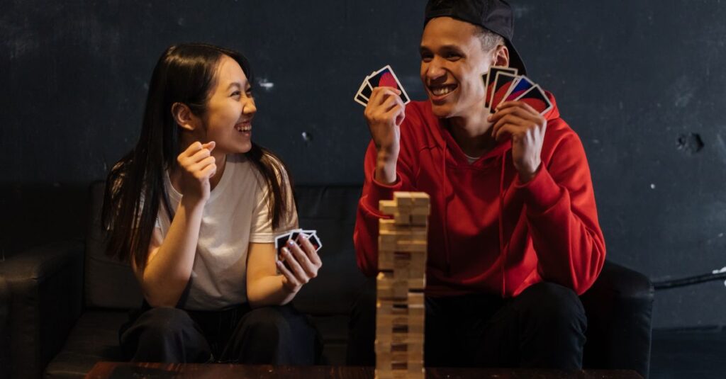 爆笑しながらボードゲームを楽しむ若者グループの様子