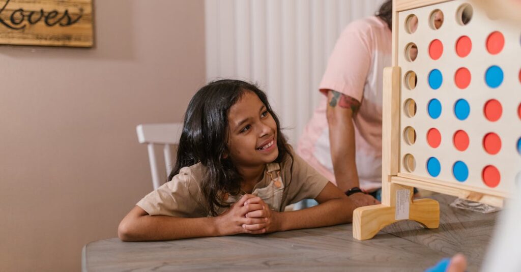 小学生の子どもと家族がカタンジュニアを遊んでいる様子。相談しながらコマを置く場面。