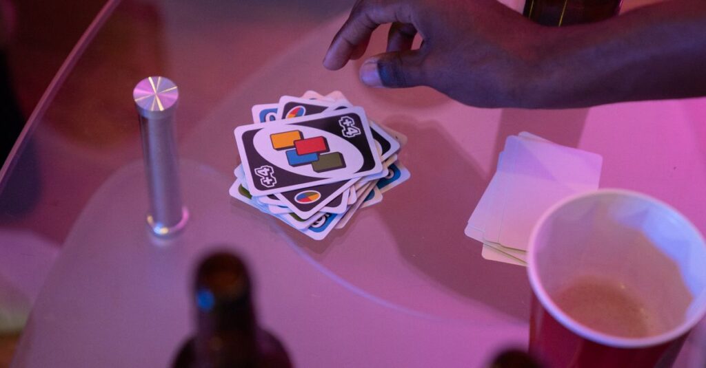 家族がUNOカードを手に笑顔で遊んでいる様子。世代を超えて盛り上がるシーン。